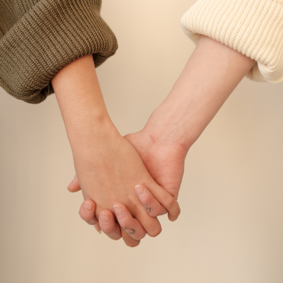 Two people holding hands in a supportive gesture, symbolising care and connection in eating disorder recovery.